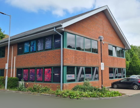 The Awdry Law Marlborough office at 7 Woodstock Court, Blenheim Road: a contemporary two-storey brick-and-stone office building on Marlborough Business Park, the Awdry Law signage on the front wall, free parking visible in the foreground.